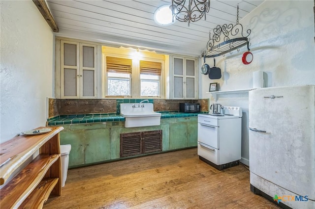 959 Highland Dr, Bandera, TX 78003 - kitchen featuring white appliances, wood finished floors, open shelves, a textured wall, and decorative backsplash