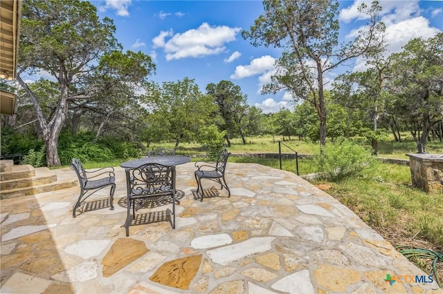959 Highland Dr, Bandera, TX 78003 - view of patio featuring view of wooded area and outdoor dining area