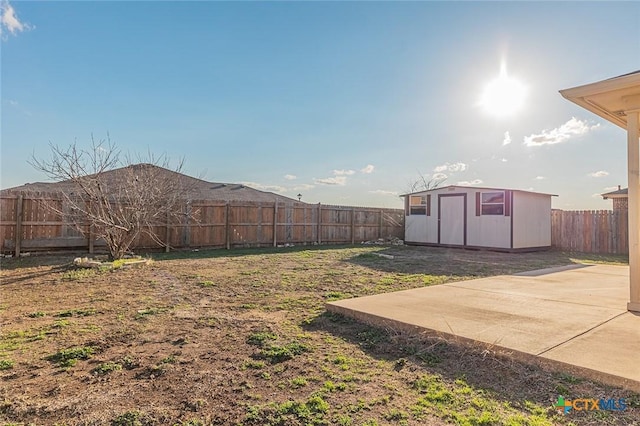 view of yard featuring a storage unit and a patio