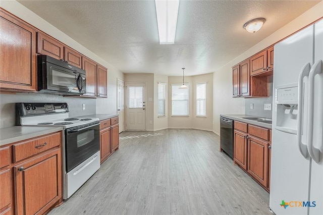 kitchen featuring hanging light fixtures, a textured ceiling, light hardwood / wood-style floors, and black appliances