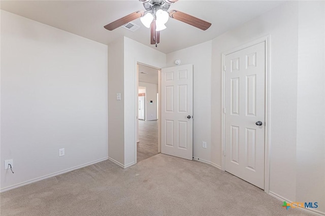 unfurnished bedroom with ceiling fan and light colored carpet