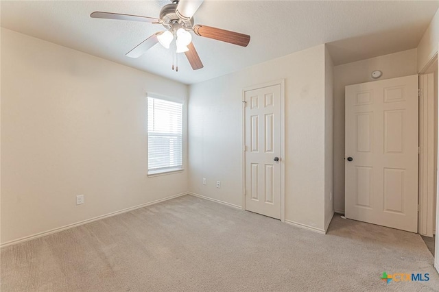 unfurnished bedroom featuring light colored carpet and ceiling fan