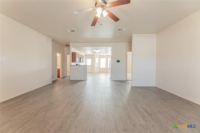 unfurnished living room featuring ceiling fan and hardwood / wood-style floors