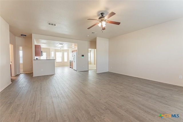 unfurnished living room with hardwood / wood-style flooring and ceiling fan