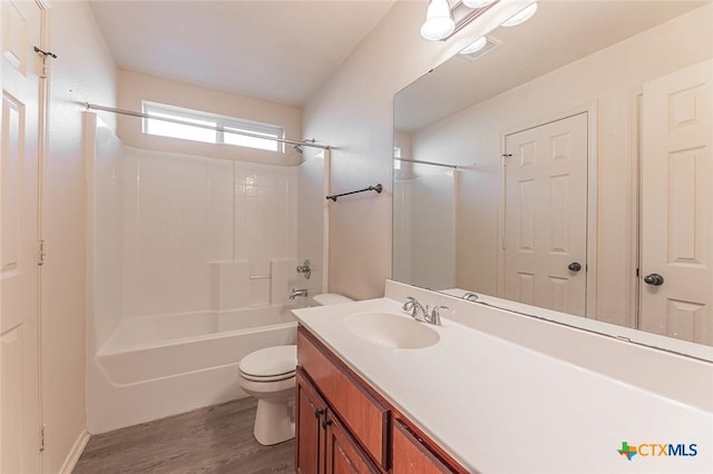 full bathroom featuring hardwood / wood-style flooring, vanity, toilet, and shower / bathing tub combination