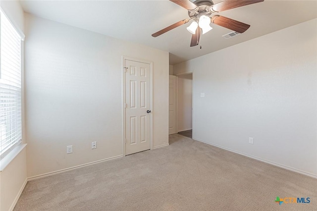 carpeted spare room featuring ceiling fan