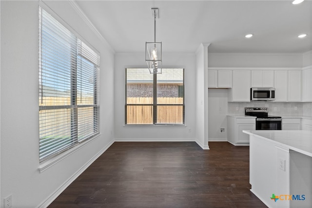 kitchen featuring backsplash, white cabinets, dark hardwood / wood-style floors, decorative light fixtures, and stainless steel appliances