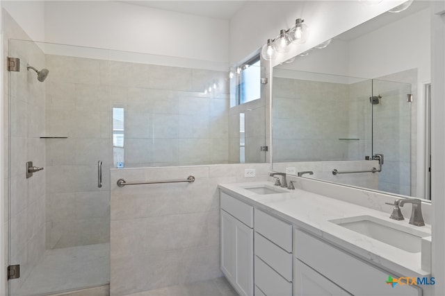 bathroom featuring vanity, an enclosed shower, and tile walls