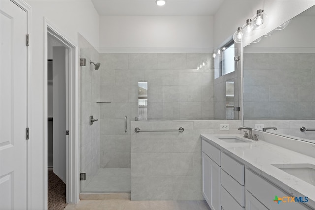 bathroom featuring tile patterned flooring, vanity, and a shower with shower door