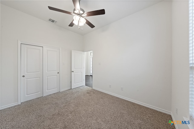 unfurnished bedroom featuring carpet, ceiling fan, and a closet