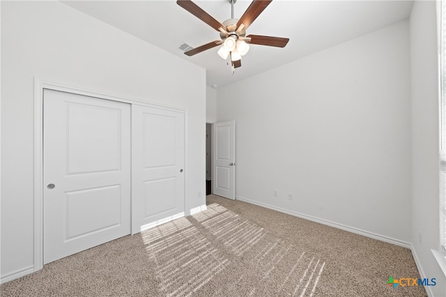 unfurnished bedroom featuring carpet flooring, ceiling fan, and a closet