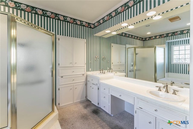 full bathroom featuring a sink, a stall shower, double vanity, and wallpapered walls