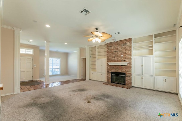 unfurnished living room with visible vents, ornate columns, ceiling fan, crown molding, and carpet flooring