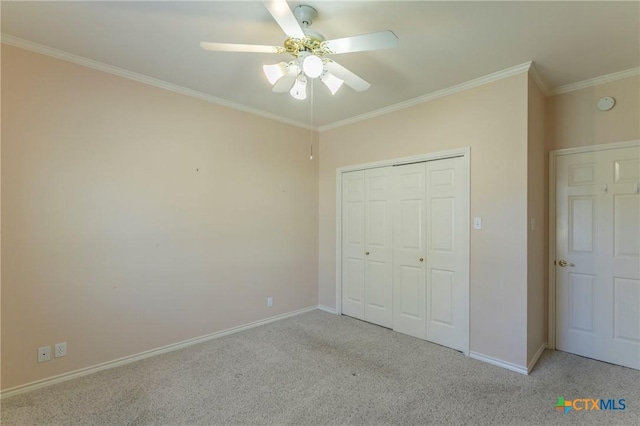 unfurnished bedroom with a ceiling fan, carpet, baseboards, ornamental molding, and a closet