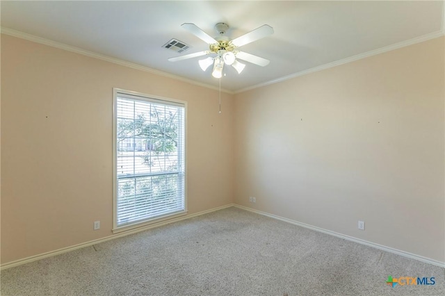 spare room featuring visible vents, a ceiling fan, carpet flooring, crown molding, and baseboards