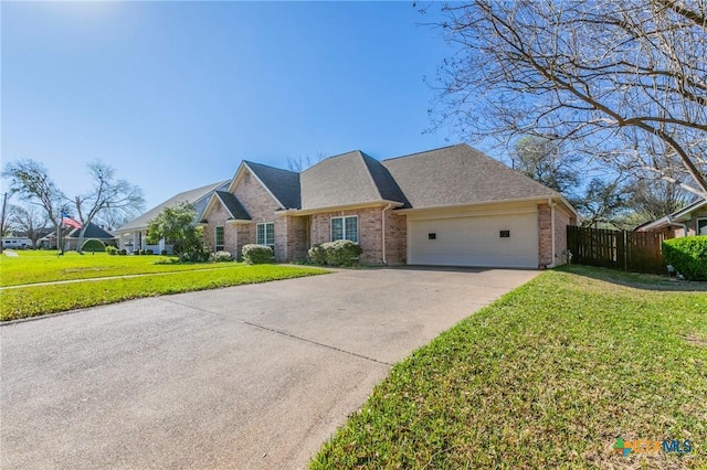 view of front of home with driveway, a front lawn, fence, a garage, and brick siding