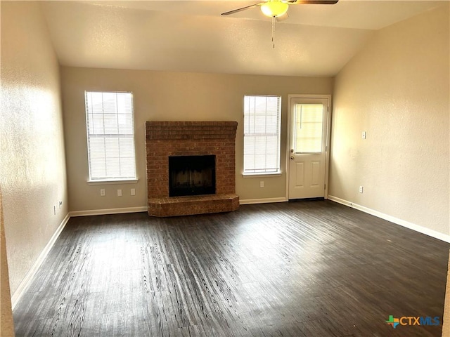 unfurnished living room featuring a brick fireplace, ceiling fan, dark hardwood / wood-style flooring, and vaulted ceiling