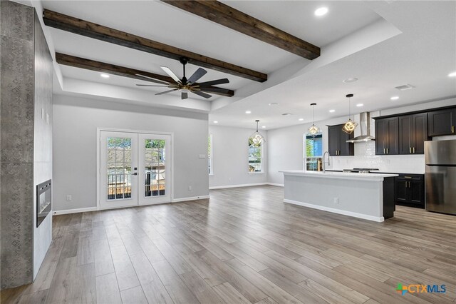 9923 Loma Alta Cir, Converse, TX 78109 - unfurnished living room with ceiling fan, recessed lighting, light wood-style flooring, beam ceiling, and french doors