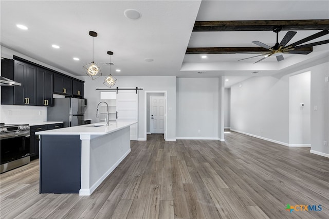 9923 Loma Alta Cir, Converse, TX 78109 - kitchen featuring stainless steel appliances, a barn door, light countertops, an island with sink, and open floor plan