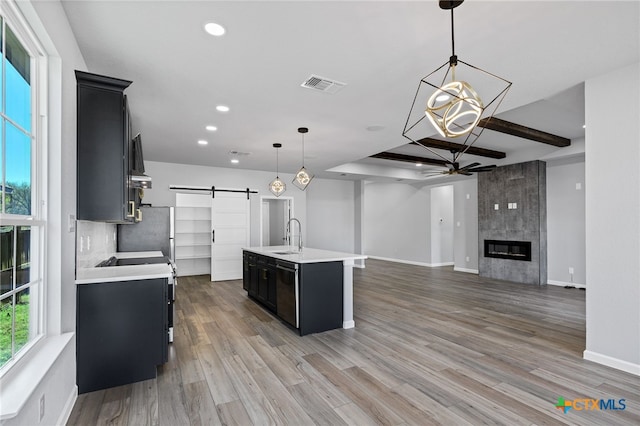 9923 Loma Alta Cir, Converse, TX 78109 - kitchen with a barn door, dark cabinets, ceiling fan, light countertops, and recessed lighting