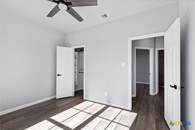 9923 Loma Alta Cir, Converse, TX 78109 - unfurnished bedroom featuring wood finished floors, a closet, a ceiling fan, and a walk in closet