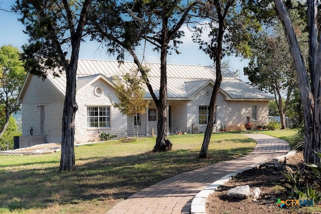 10306 Vance Circle Rd, Jonestown, TX 78645 - single story home featuring a front yard, stone siding, a metal roof, and a standing seam roof