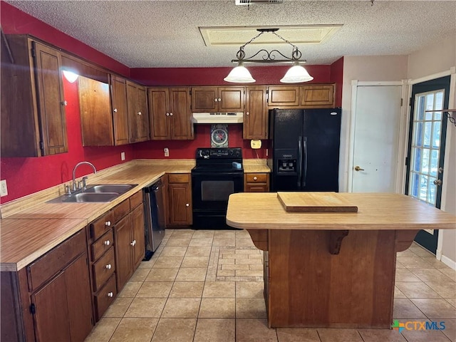 kitchen featuring a center island, under cabinet range hood, a textured ceiling, black appliances, and a sink