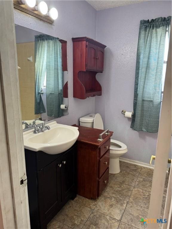 bathroom featuring vanity, tile patterned floors, toilet, and baseboards