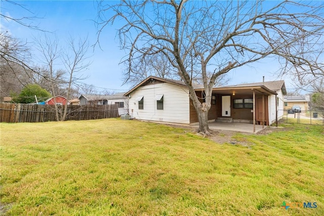 back of property with a yard, a patio, and fence