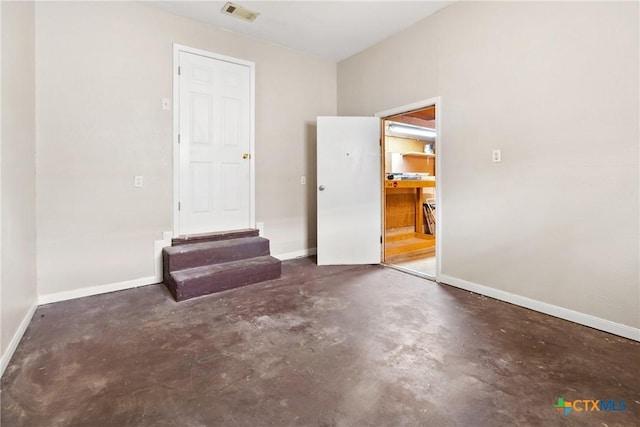 spare room with concrete floors, visible vents, and baseboards