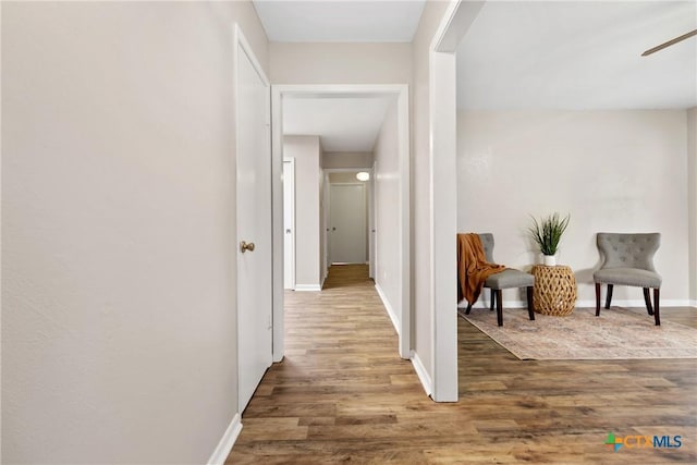 corridor with wood finished floors and baseboards