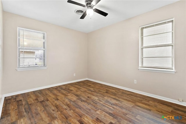 spare room featuring a ceiling fan, baseboards, and wood finished floors