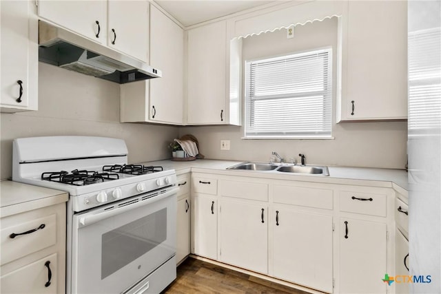 kitchen featuring under cabinet range hood, white range with gas stovetop, light countertops, and a sink