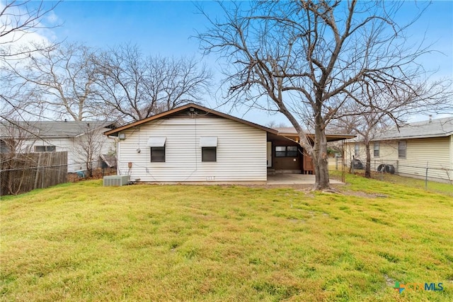 back of house with fence, central AC, and a yard