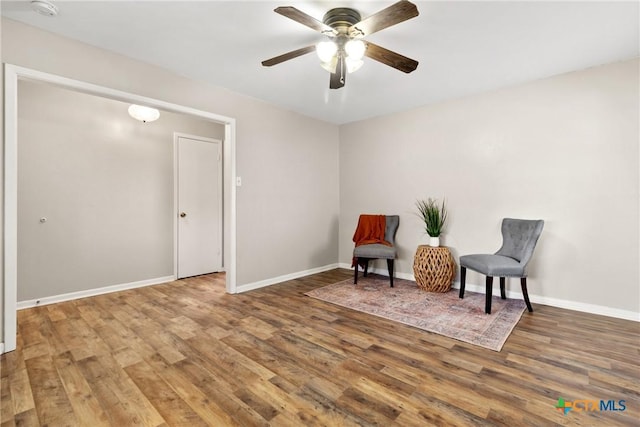 sitting room featuring wood finished floors, a ceiling fan, and baseboards