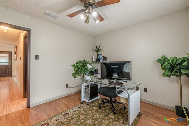 office area featuring a textured ceiling, light hardwood / wood-style floors, and ceiling fan