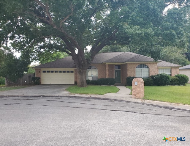 ranch-style house featuring a garage and a front yard