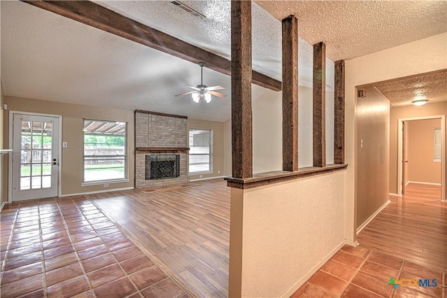 2006 Canyon Creek Dr, Temple, TX 76502 - unfurnished living room with a textured ceiling, a ceiling fan, a brick fireplace, and tile patterned floors
