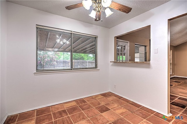 2006 Canyon Creek Dr, Temple, TX 76502 - empty room with a textured ceiling, ceiling fan, and dark tile patterned floors