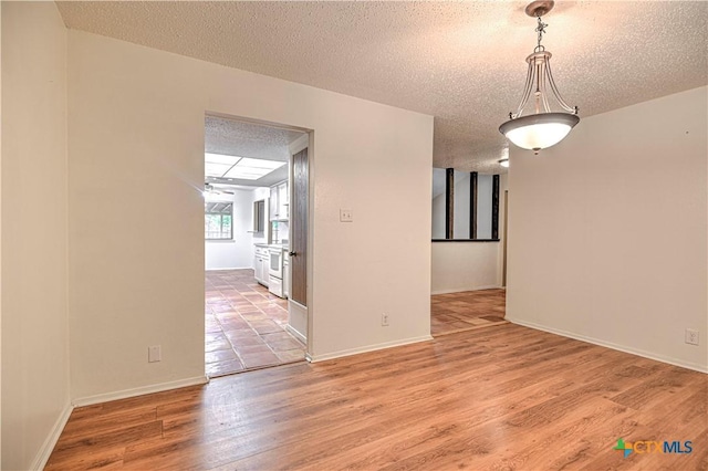 2006 Canyon Creek Dr, Temple, TX 76502 - spare room with light wood-style flooring and a textured ceiling