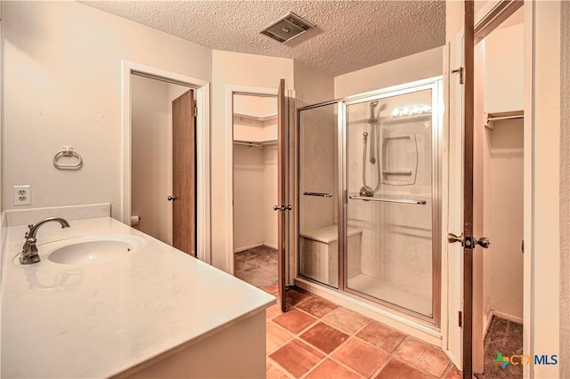 2006 Canyon Creek Dr, Temple, TX 76502 - bathroom with vanity, a spacious closet, a shower stall, and a textured ceiling