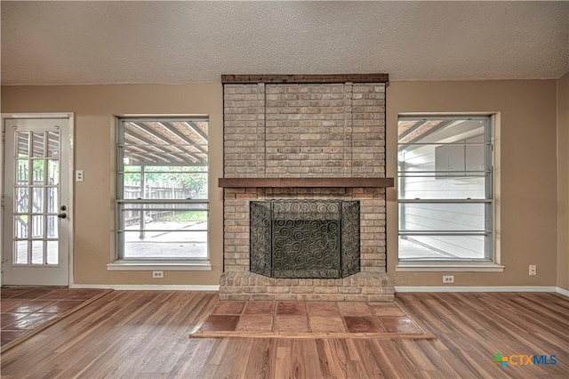 2006 Canyon Creek Dr, Temple, TX 76502 - unfurnished living room featuring a textured ceiling, wood finished floors, and a fireplace