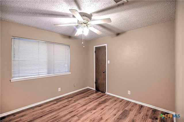 2006 Canyon Creek Dr, Temple, TX 76502 - empty room featuring wood finished floors, a textured ceiling, and a ceiling fan
