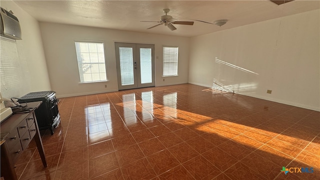 tiled empty room with ceiling fan, a wall unit AC, and french doors