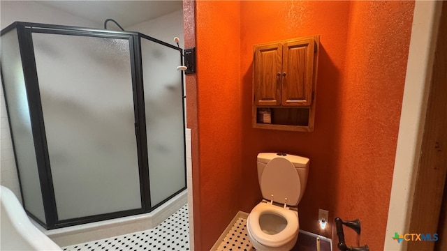 bathroom with a shower with door and toilet