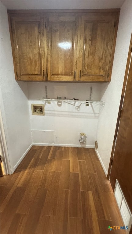 laundry area with cabinets, dark wood-type flooring, and hookup for a washing machine