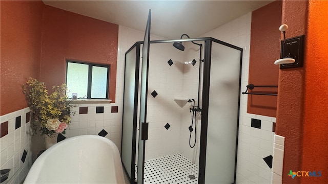 bathroom featuring tile walls and independent shower and bath