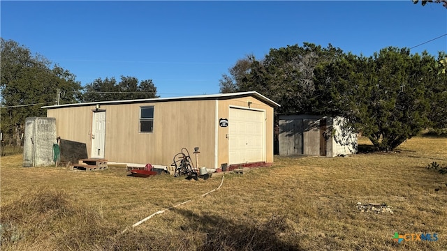 view of outbuilding featuring a yard and a garage