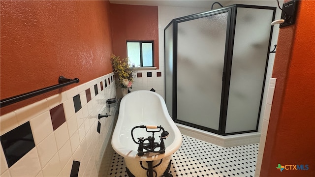 bathroom featuring tile walls and independent shower and bath