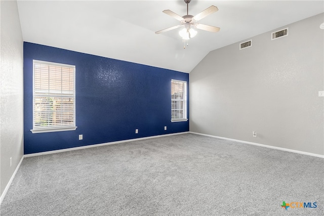 carpeted spare room with ceiling fan and vaulted ceiling